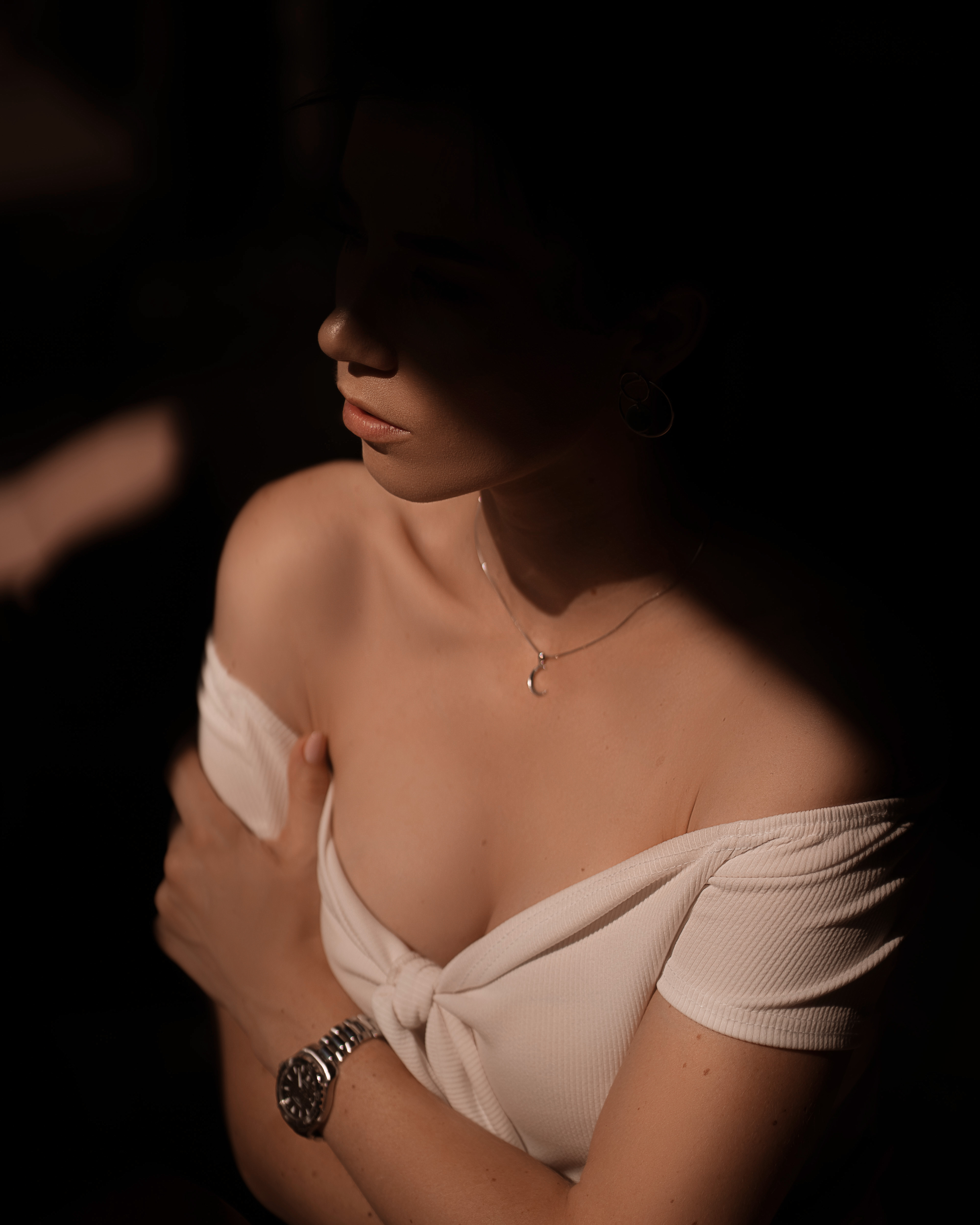 Retrato editorial em preto e branco: luz e sombra sobre ombros e colo
